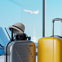 Zwei Koffer mit Hut und Kamera am Flughafen