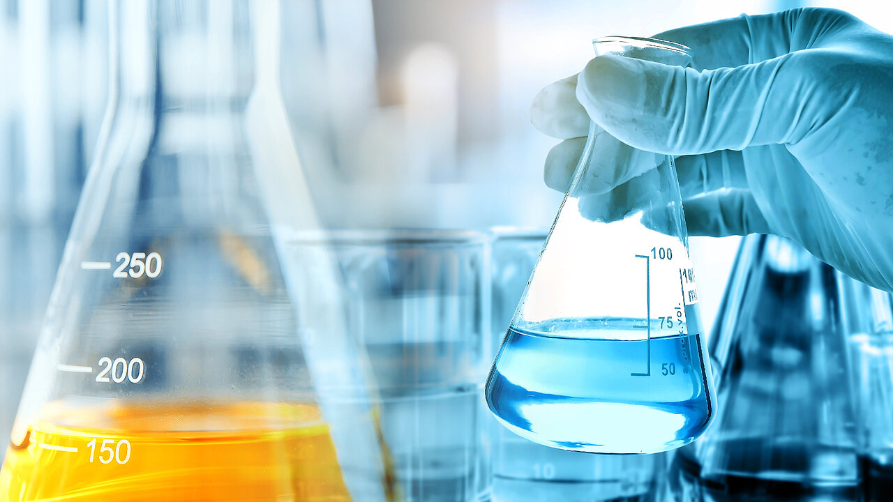 Hand hält Kolben in einem medizinischen Labor