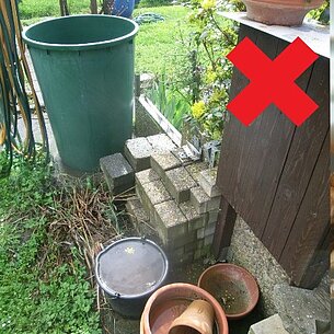Regenwassertonne, Blumentöpfe und Untersetzer gefüllt mit Wasser als Brutstätte für Mücken
