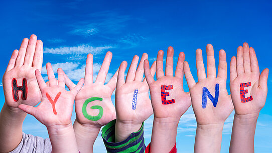 Sieben bemalte Kinderhände bilden das Wort "Hygiene"
