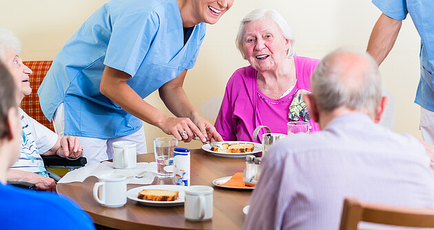 Gruppe von Senioren beim Essen im Pflegeheim