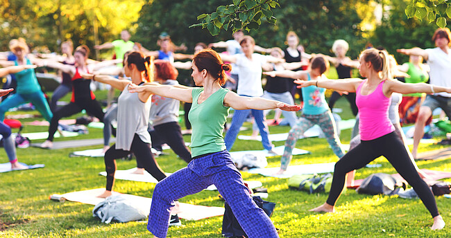 Junge Menschen praktizieren Yoga im Park