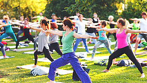 Junge Menschen praktizieren Yoga im Park
