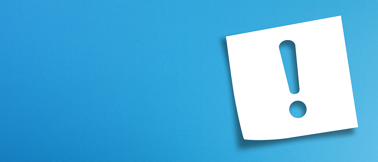 Notizpapier mit Ausrufezeichen auf blauem Hintergrund