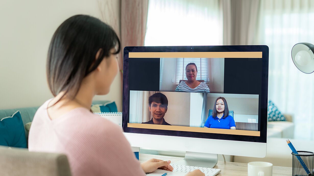 Frau spricht mit ihren Kolleginnen und Kollegen in einer Videokonferenz