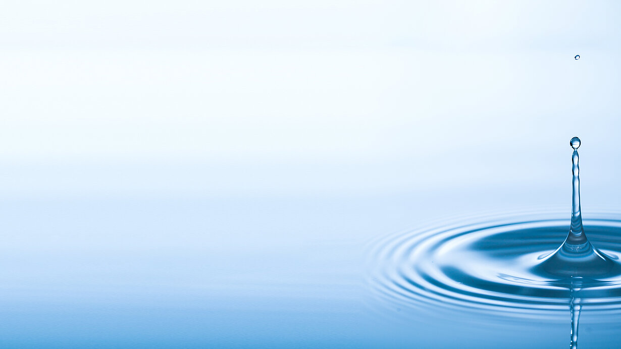 Tropfen fällt auf glatte Wasseroberfläche