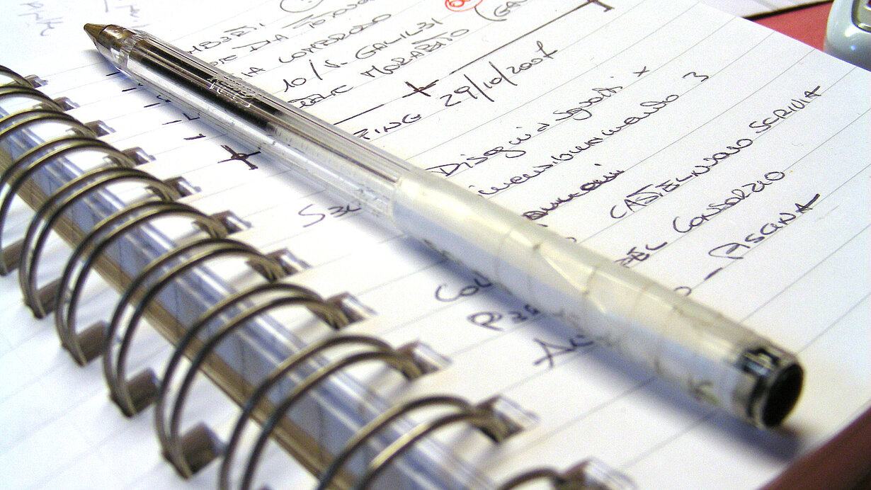 Ringbuch mit Notizen und Stift