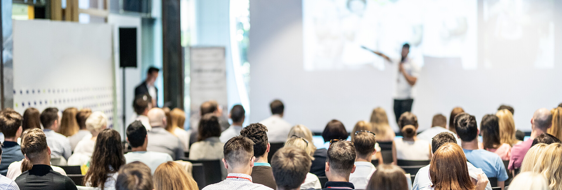 Sprecher hält einen Vortrag vor Publikumbei einer Veranstaltung im Saal