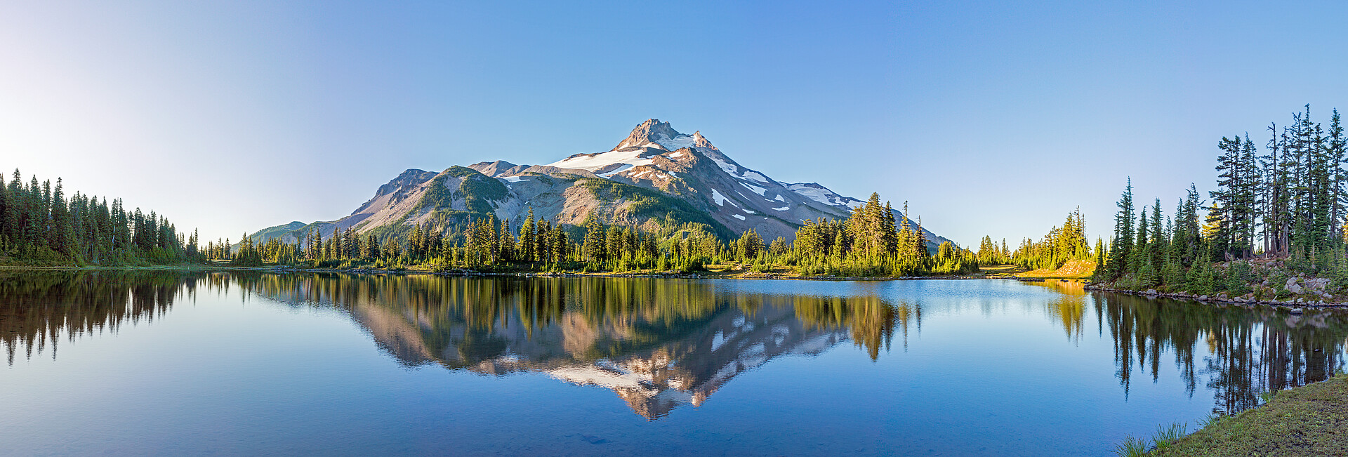 Berg spiegelt sich im Morgenlicht im See