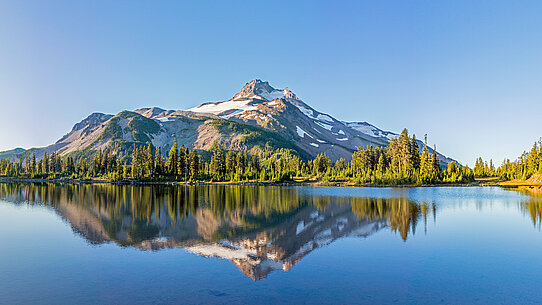 Berg spiegelt sich im Morgenlicht im See