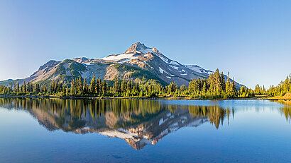 Berg spiegelt sich im Morgenlicht im See