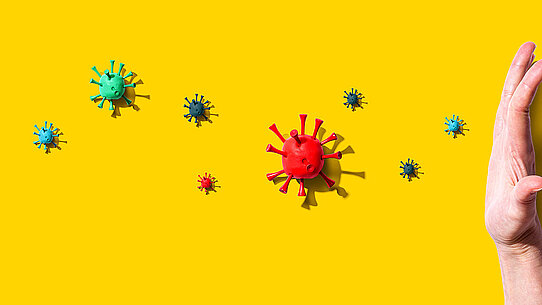 Hand stoppt anfliegende Krankheitserreger