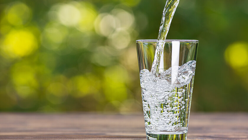 Wasserstrahl fließt in ein Trinkglas