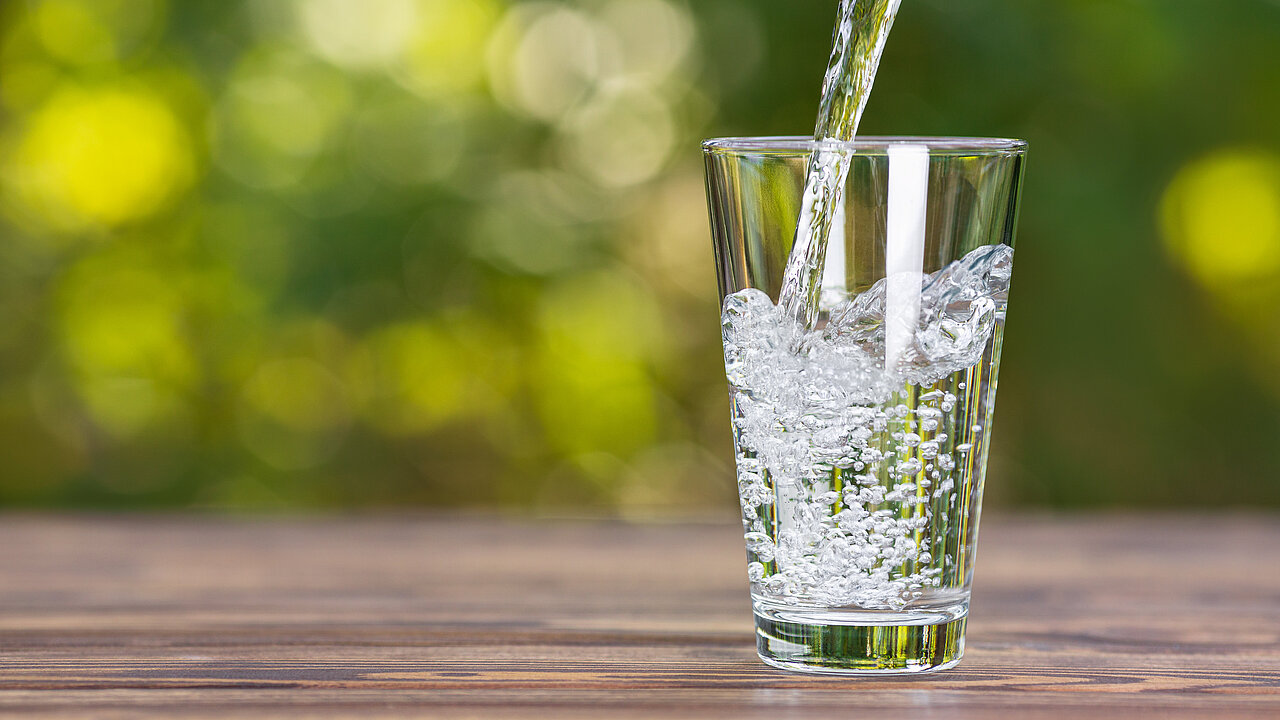 Wasserstrahl fließt in ein Trinkglas