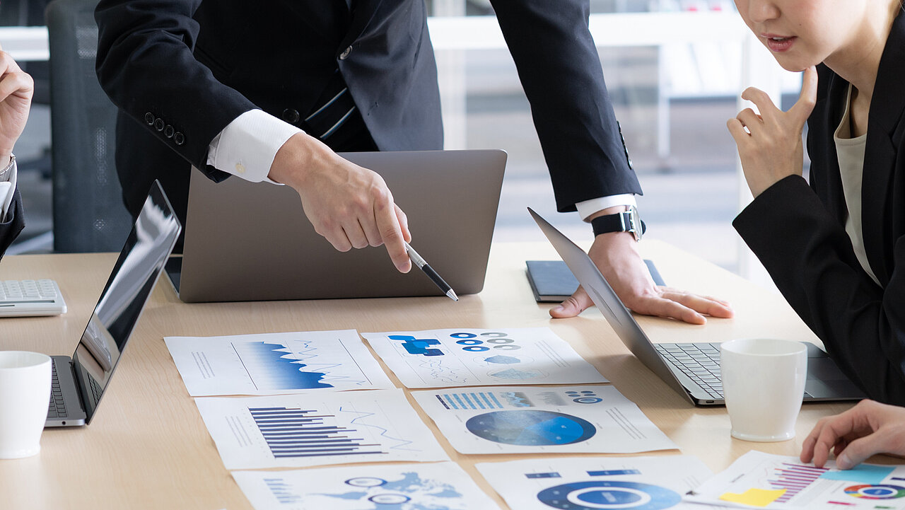 Mehrere Personen an einem Konferenztisch betrachten Diagramme