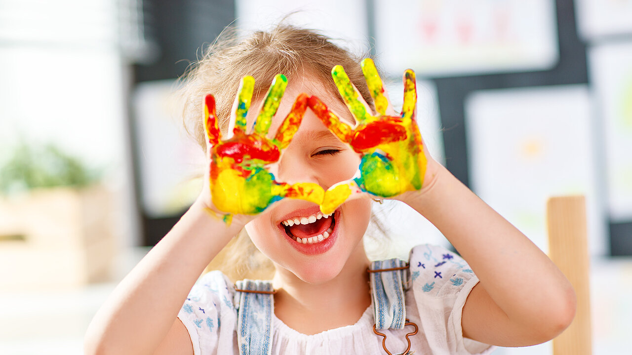 Lachendes Mädchen zeigt seine angemalten Hände