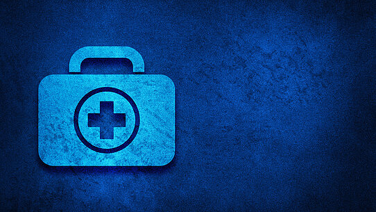 Erste-Hilfe-Kasten vor blauem Hintergrund